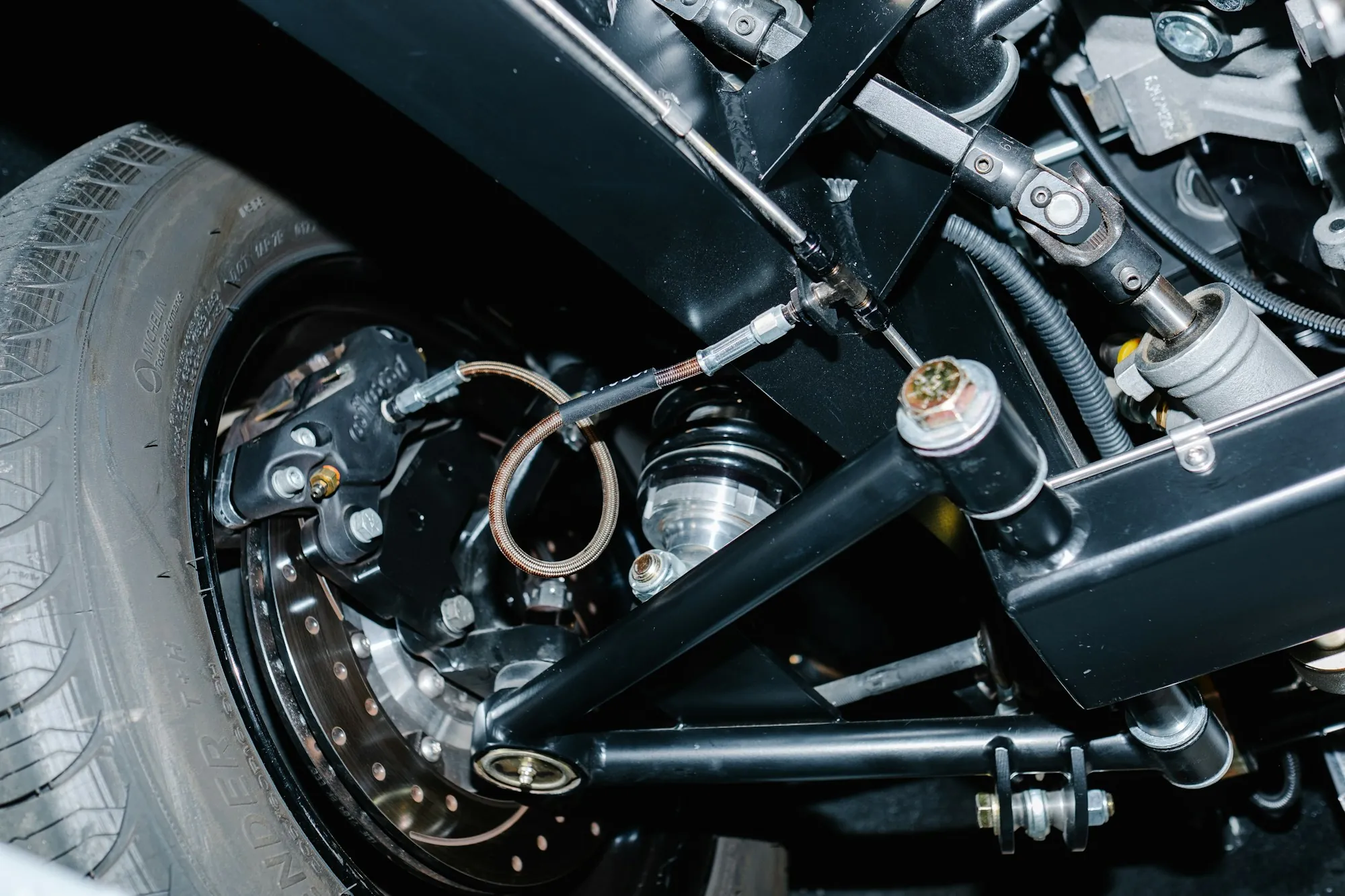 Front suspension assembly and coil spring visible behind a wheel hub