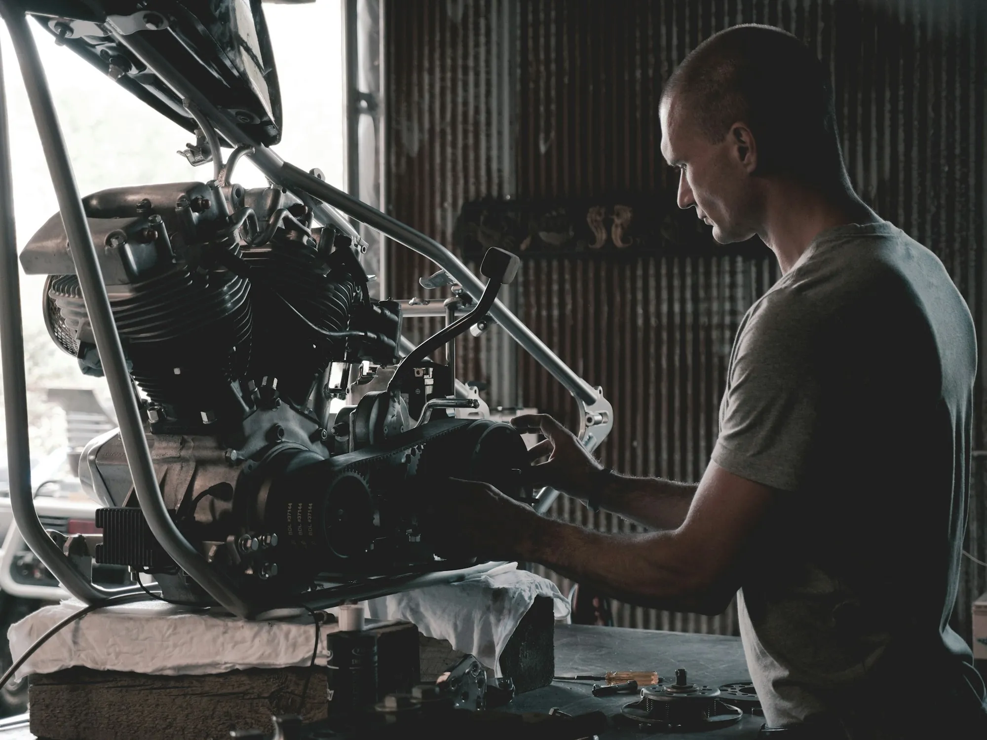 Technician leaning into an open engine bay while checking a component